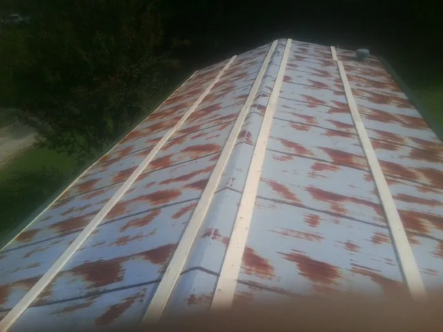 Rusted metal roof panels with new wood purlins before replacement in Grand Rapids